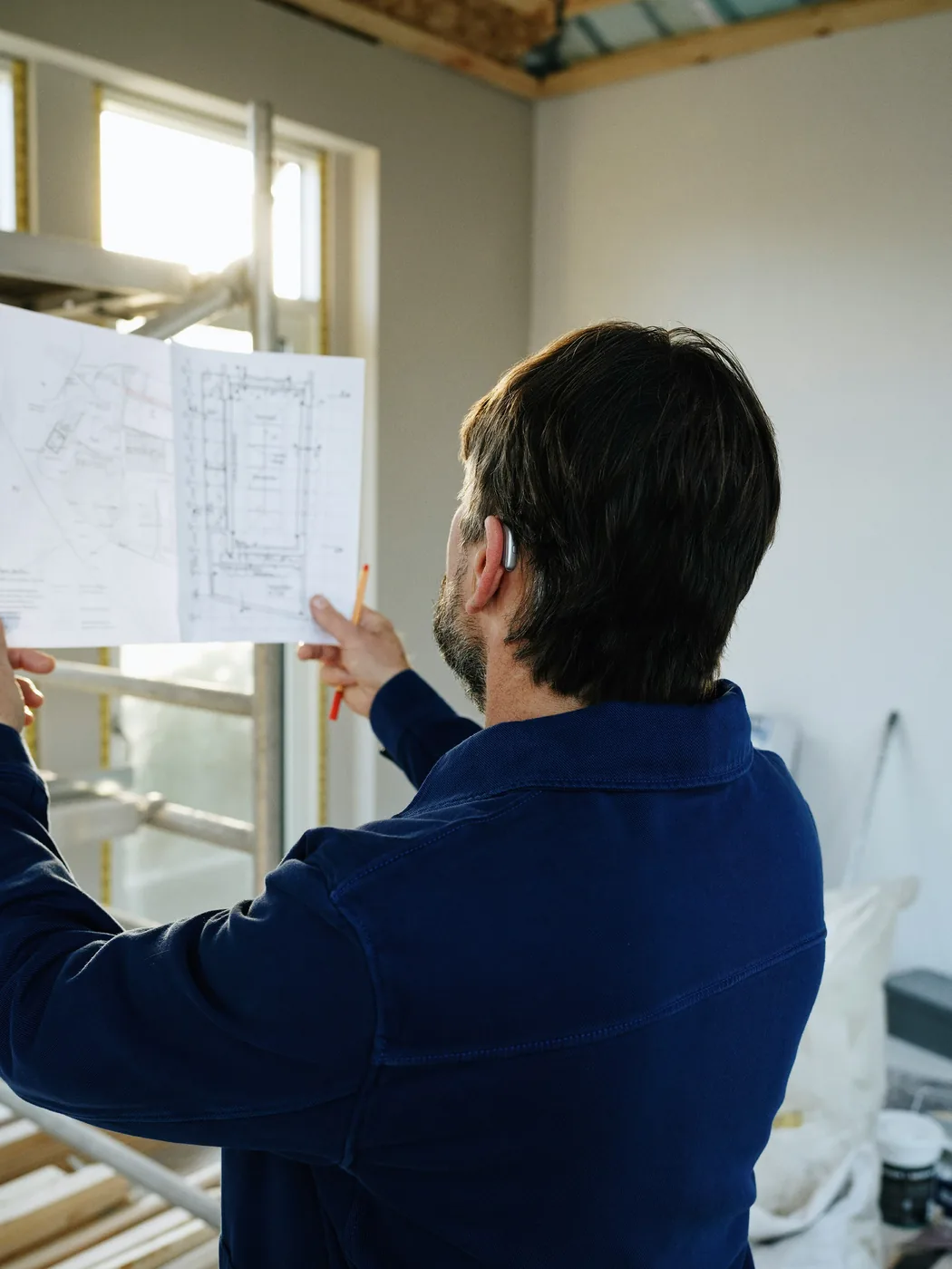 Professional reviewing construction drawings on site